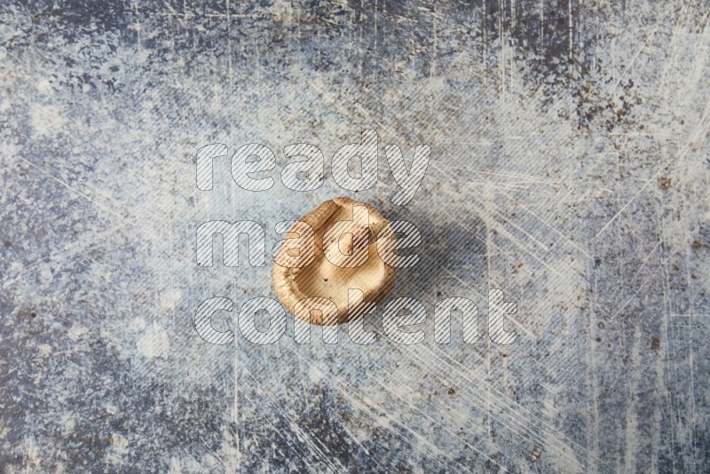 single fresh shiitake Mushroom topview  on a blue textured background