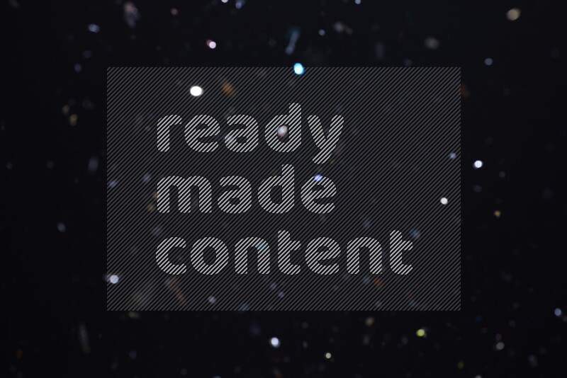 Falling multicolored confetti on black background