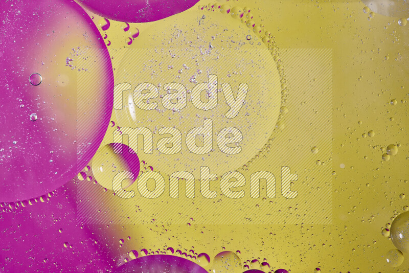 لقطات مقربة لفقاعات من الزيت على سطح الماء باللون الأصفر والوردي