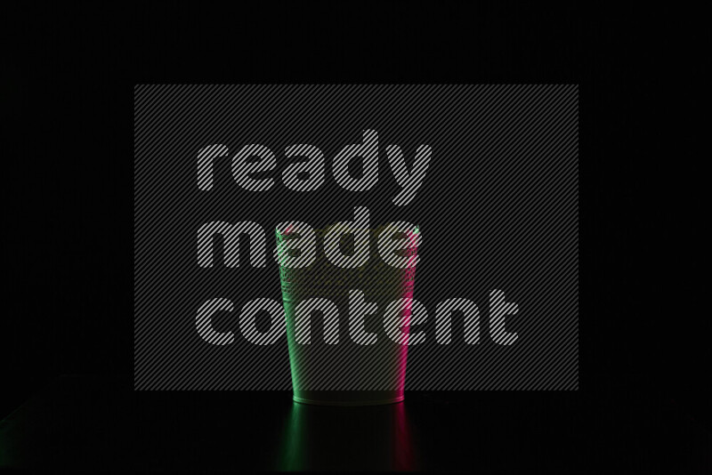 A plant pot with colored rim light against black background