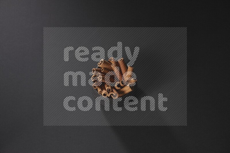 أعواد القرفة في وعاء فخاري أسود علي خلفية سوداء