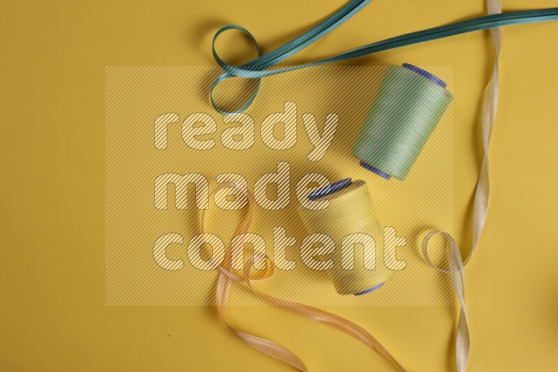 A green collection of sewing and tailoring tools arranged on a yellow background