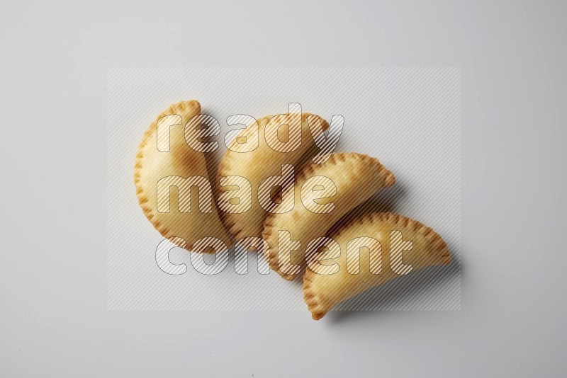 Four fried sambosa from a top angle on a white background