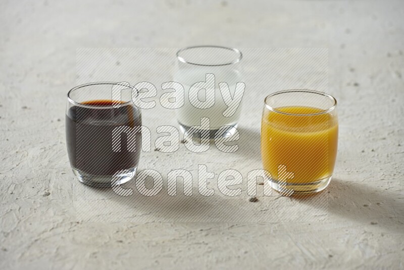 Cold drinks in a glass cup such as water, tamarind, qamar eldin, sobia, milk and hibiscus on textured white background