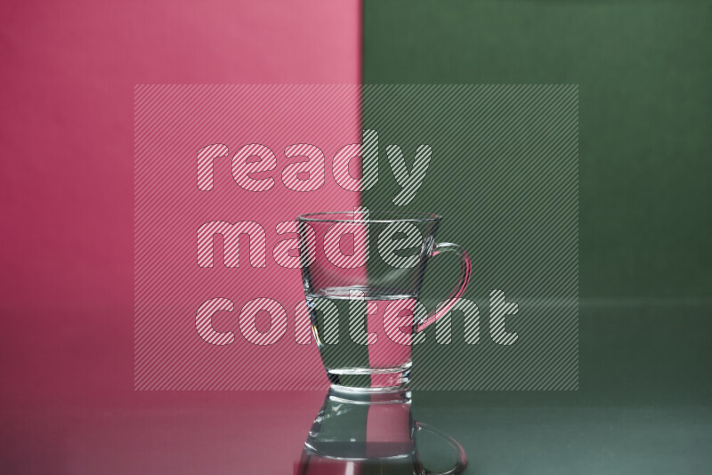 The image features a clear glassware filled with water, set against pink and dark green background