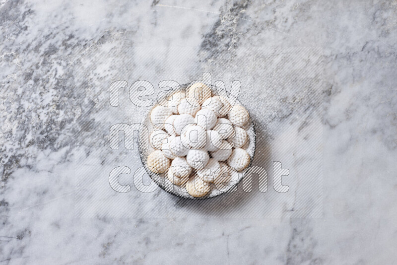 كحك في صحن فخار أسود على خلفية رخام رمادي