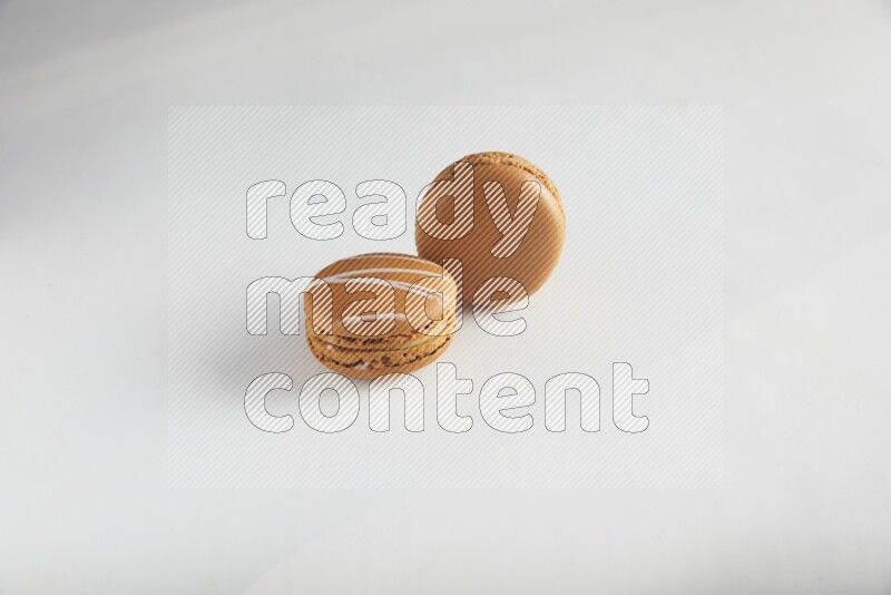 45º Shot of of two assorted Brown Irish Cream, and Brown Maple Taffy macarons  on white background