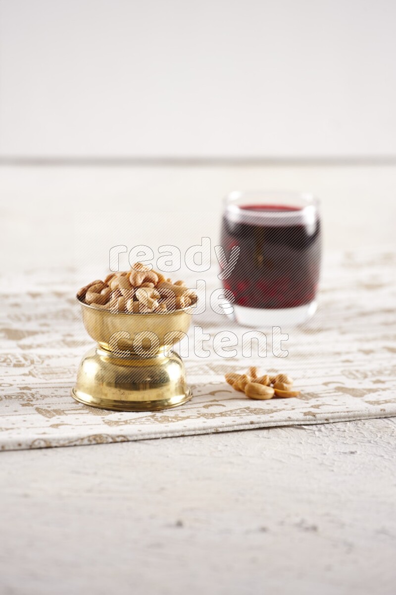 Nuts in a metal bowl with hibiscus in a light setup