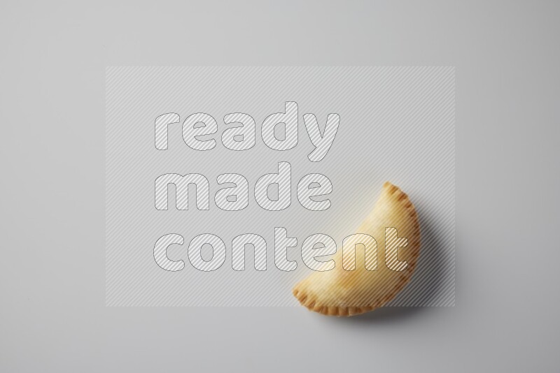 One fried sambosa from a top angle on a white background