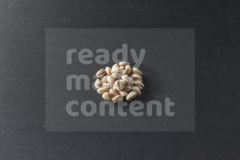 A bunch of pistachios on a black background in different angles