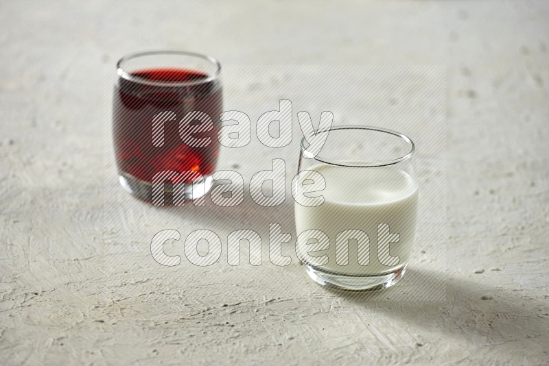 Cold drinks in a glass cup such as water, tamarind, qamar eldin, sobia, milk and hibiscus on textured white background