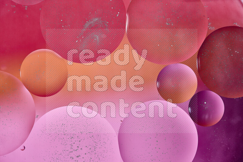 لقطات مقربة لفقاعات من الزيت على سطح الماء باللون الأحمر والبرتقالي والوردي