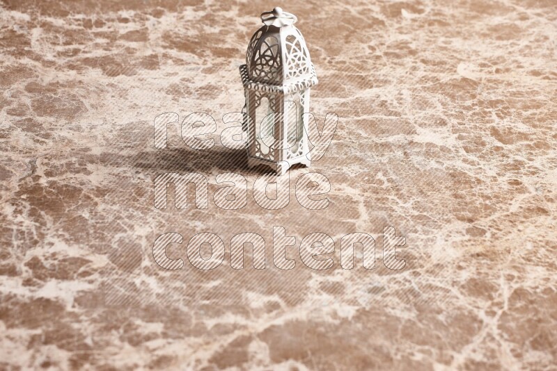 A candle lantern on beige marble background