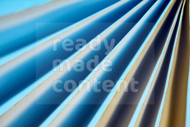 An image presenting an abstract paper pattern of lines in blue and gold tones