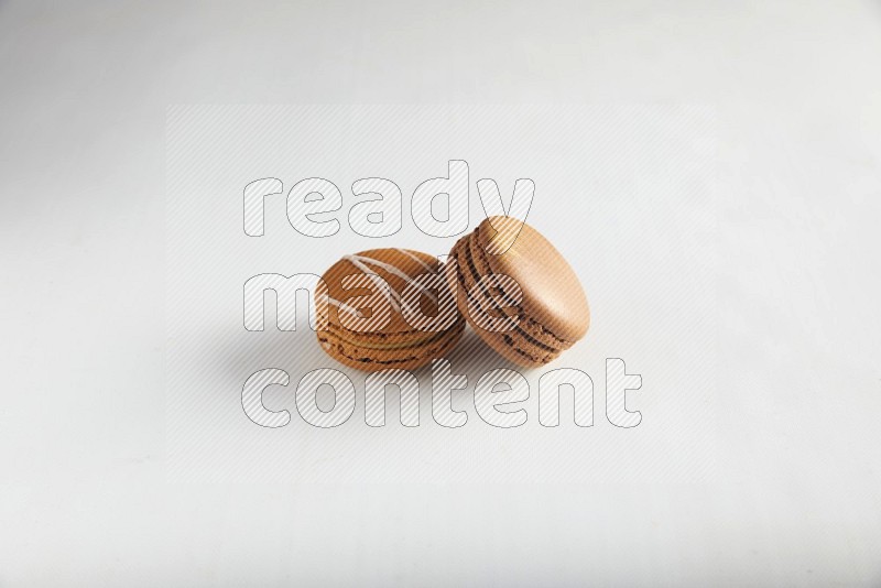 45º Shot of of two assorted Brown Irish Cream, and Brown Coffee macarons  on white background