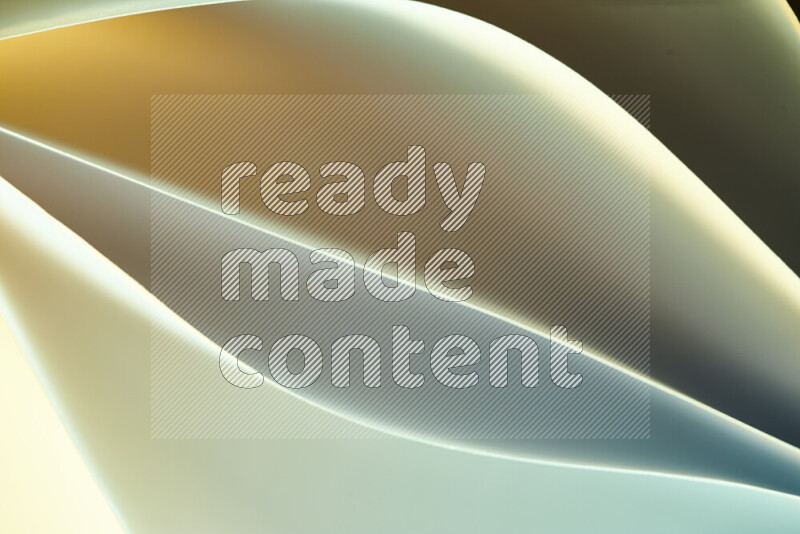 هذه الصورة تعرض تكوين فن الورق التجريدي مع منحنيات ورقية بتدرجات اللون الأخضر والأصفر المكونه بواسطة الضوء الملون