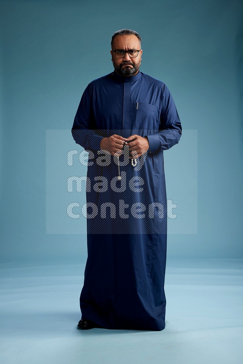 Saudi Man without shimag Standing Interacting with the camera on blue background