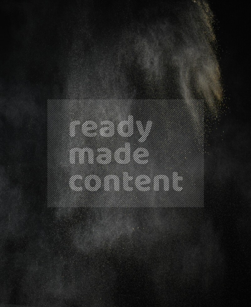 A side view of brown powder explosion on black background