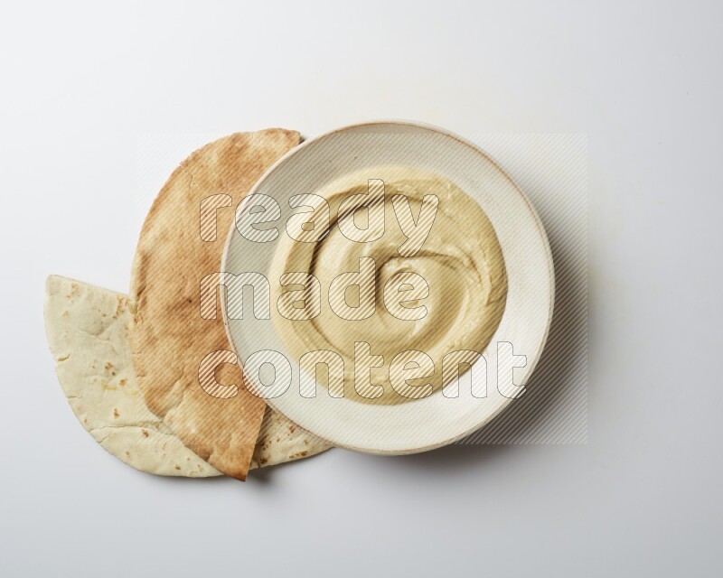 plain Hummus in a pottry plate  on a white background