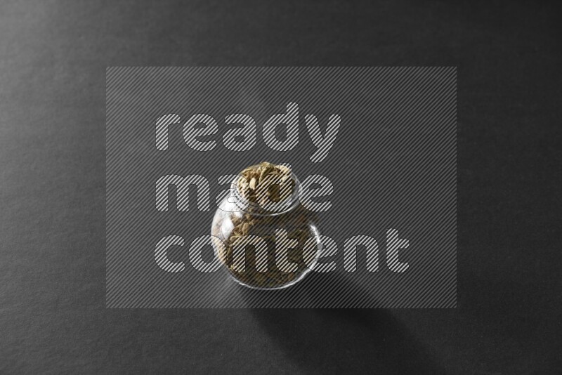 هيل في وعاء زجاجي علي خلفية سوداء