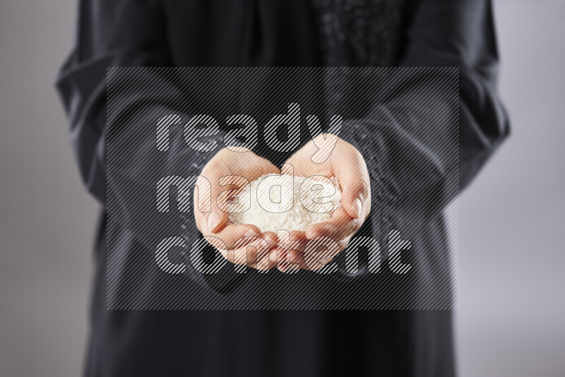 Woman in abaya holding different kinds of nuts in different positions