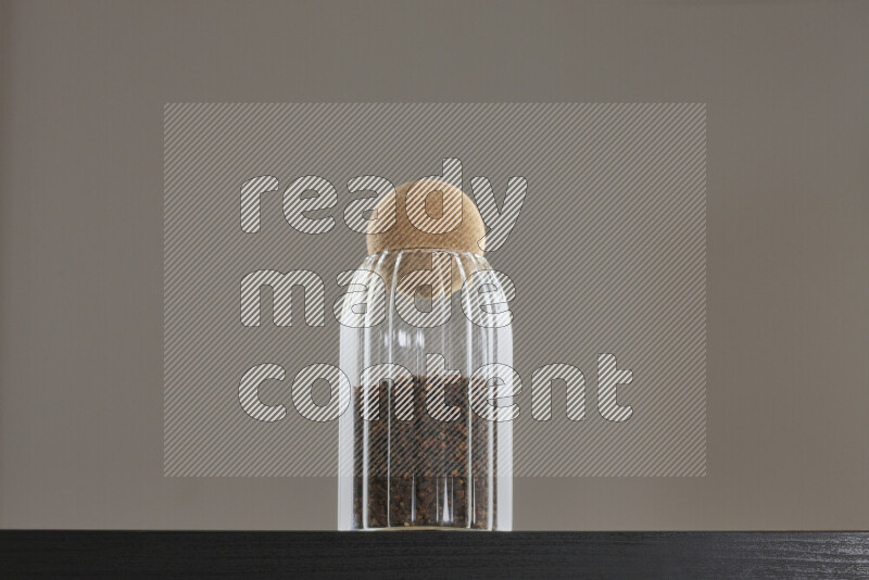 Dried basil in a glass jar on black background