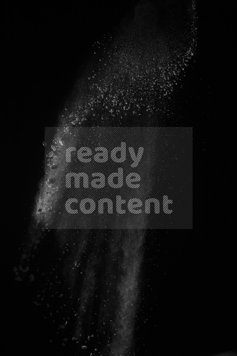 A side view of white powder explosion on black background