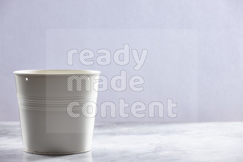 An empty white plant pot on grey marble background