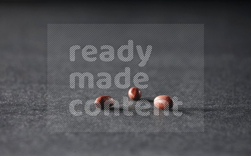 3 red skin peanuts on a black background in different angles