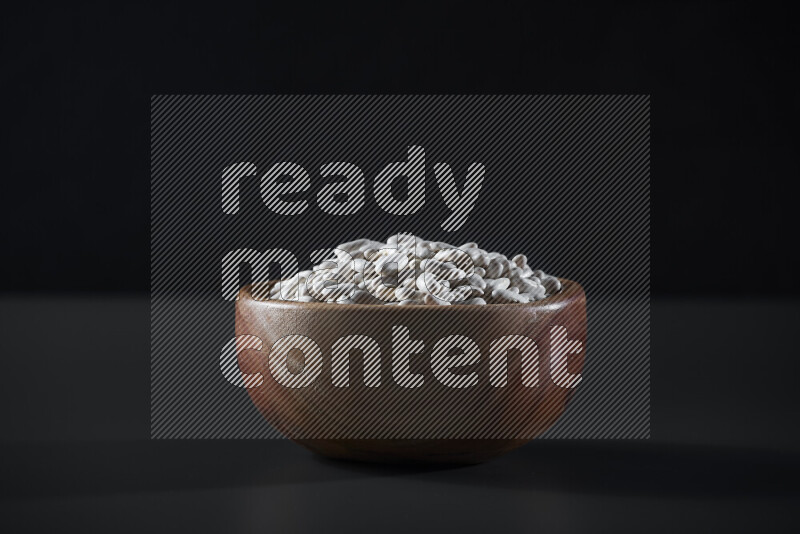 Snacks in a wooden bowl on grey background