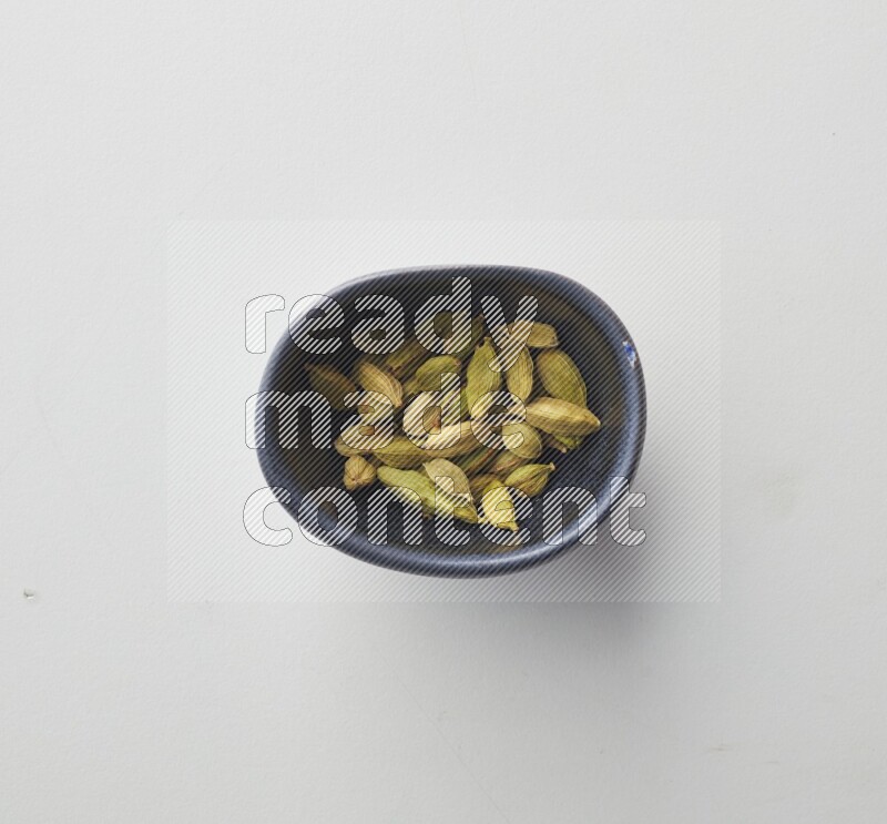 Top-view shot of Cardamon in a container on white background