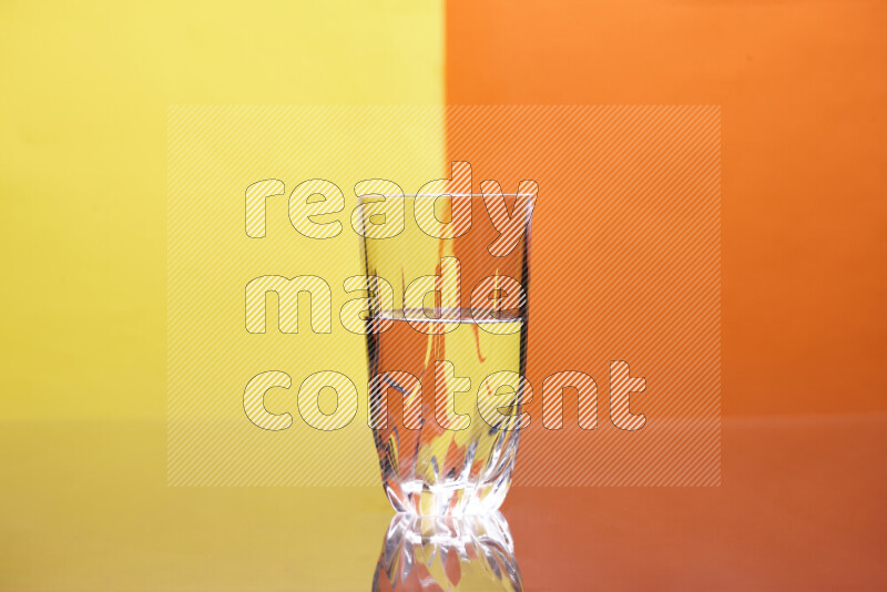 The image features a clear glassware filled with water, set against yellow and orange background