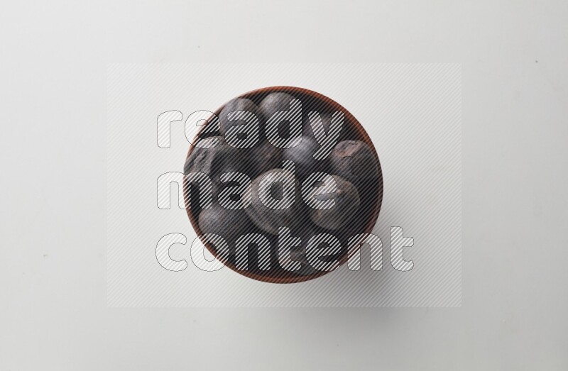 Top-view shot of dried lime (loomi) in a container on white background