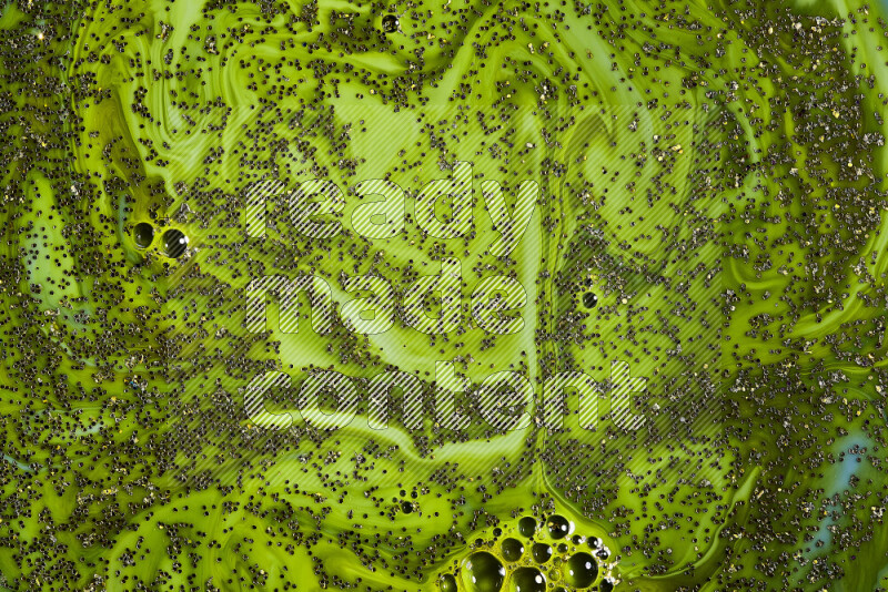 لقطة مقربة لبريق ذهبي متلألئ منتشر على خلفية من اللون الأخضر في حركات دائرية