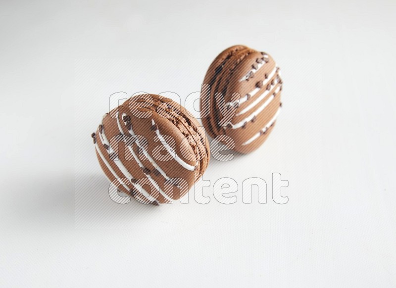 45º Shot of two Brown white Chocolate Caramel macarons on white background