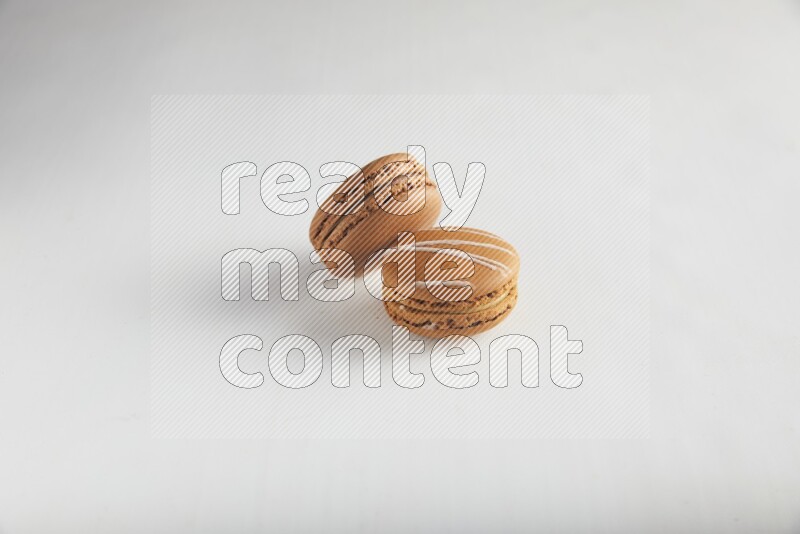 45º Shot of of two assorted Brown Irish Cream, and Brown Coffee macarons  on white background