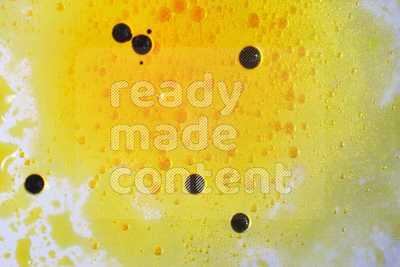 Close-ups of abstract yellow and black watercolor drops on oil Surface on white background