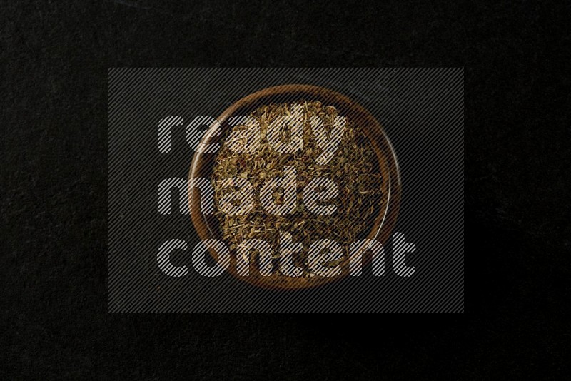 multi color round sauce bowl filled with herbs on grey textured countertop