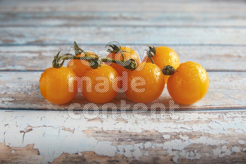 yellow cherry tomato vein on a textured blue wooden background 45 degree