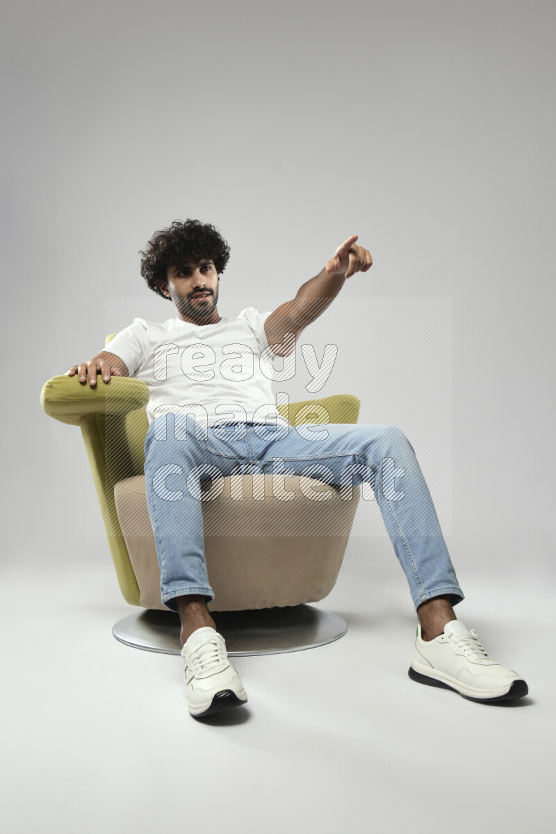 A man wearing casual sitting on a chair making a hand gesture on white background