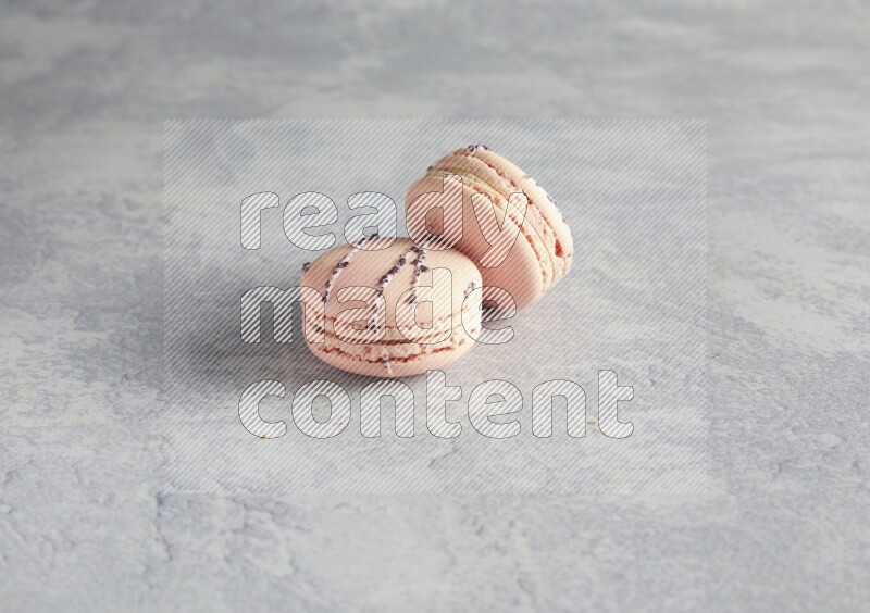 45º Shot of two pink orange blossom macarons  on white  marble background