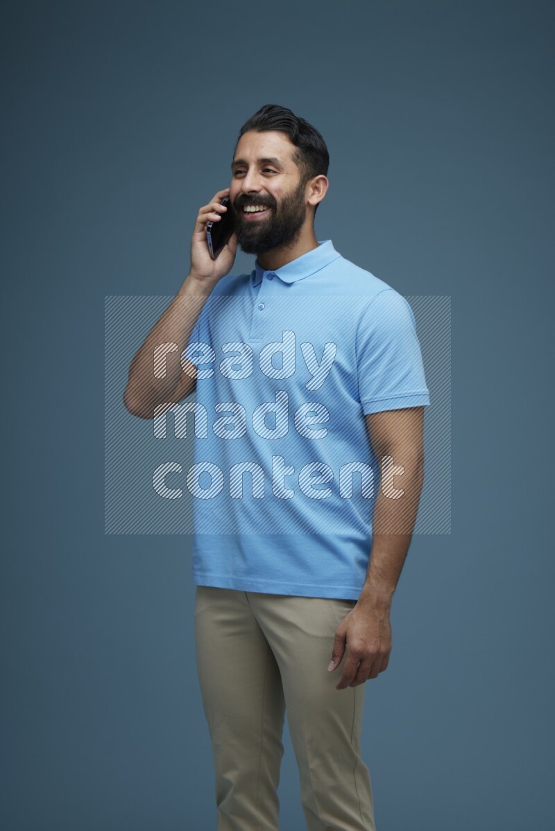 A man having a Call in a blue background wearing a Blue shirt