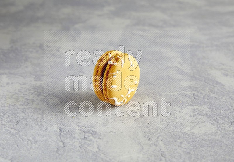 45º Shot of Yellow Piña Colada macaron on white  marble background
