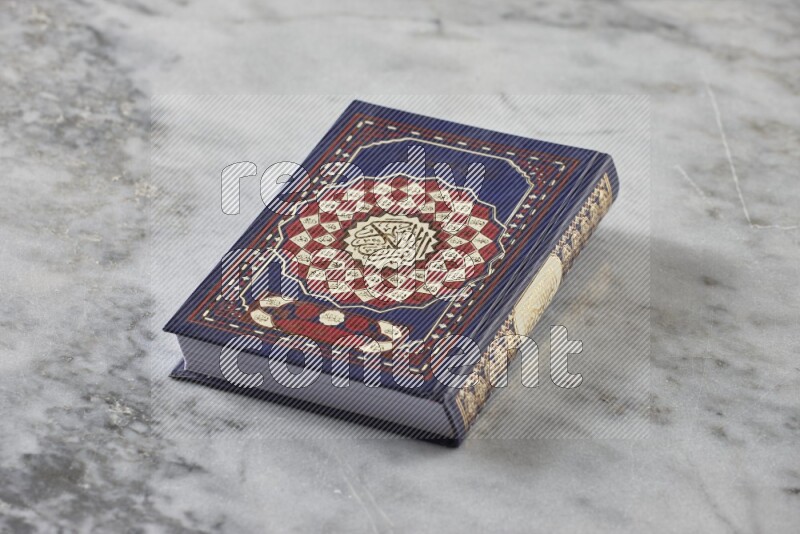 Quran with a prayer beads on grey marble background