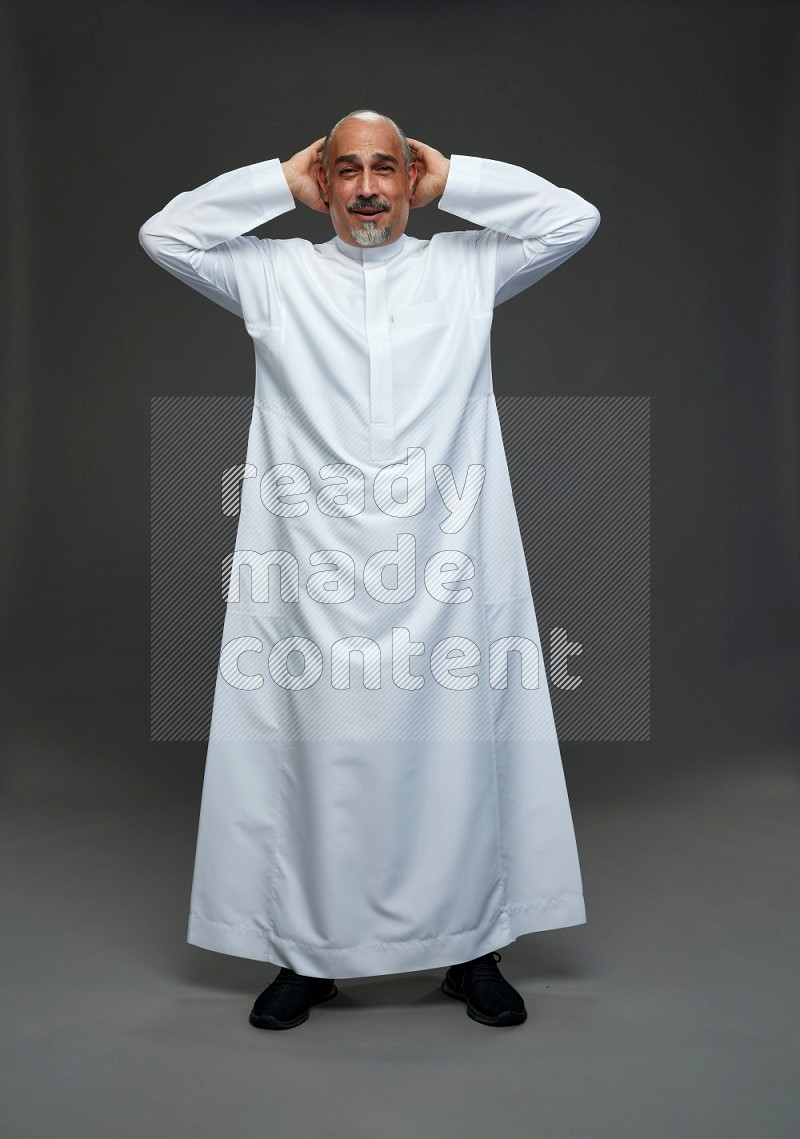 Saudi man without shomag Standing Interacting with the camera on gray background