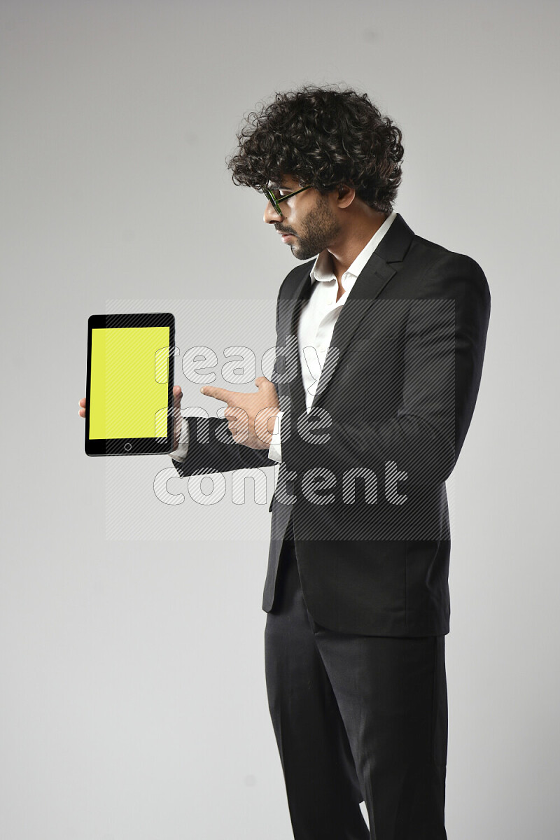 A man wearing formal standing and showing a tablet screen on white background