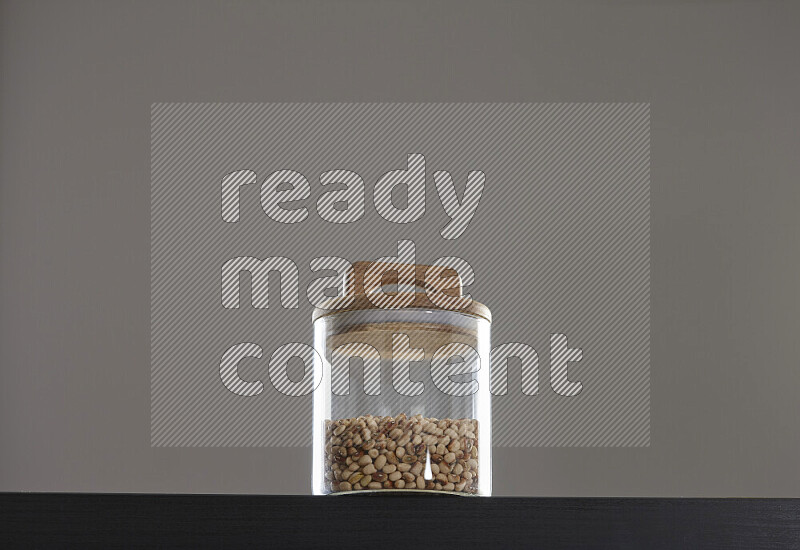 Black-eyed peas in a glass jar on black background