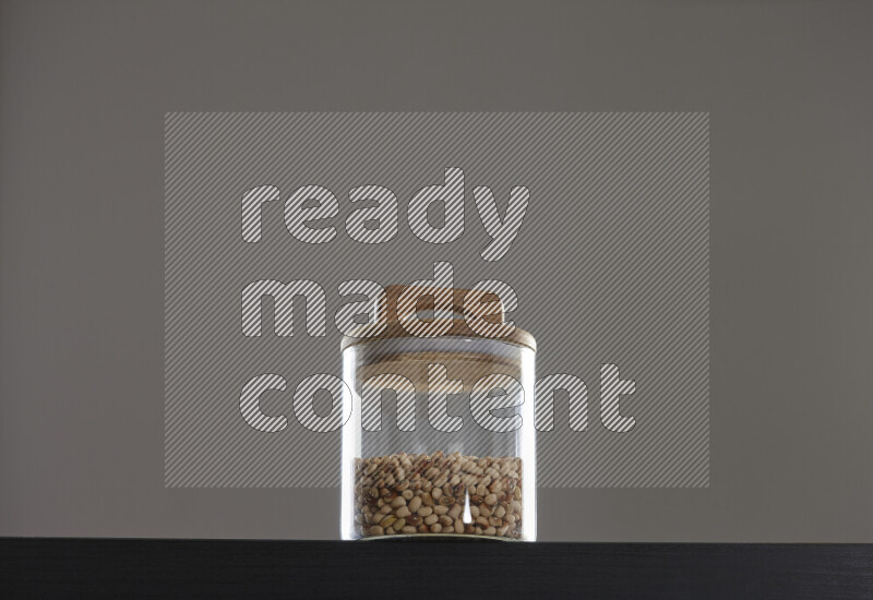 Black-eyed peas in a glass jar on black background