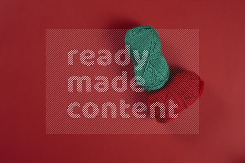 A green and red collection of sewing and tailoring tools arranged on a red background