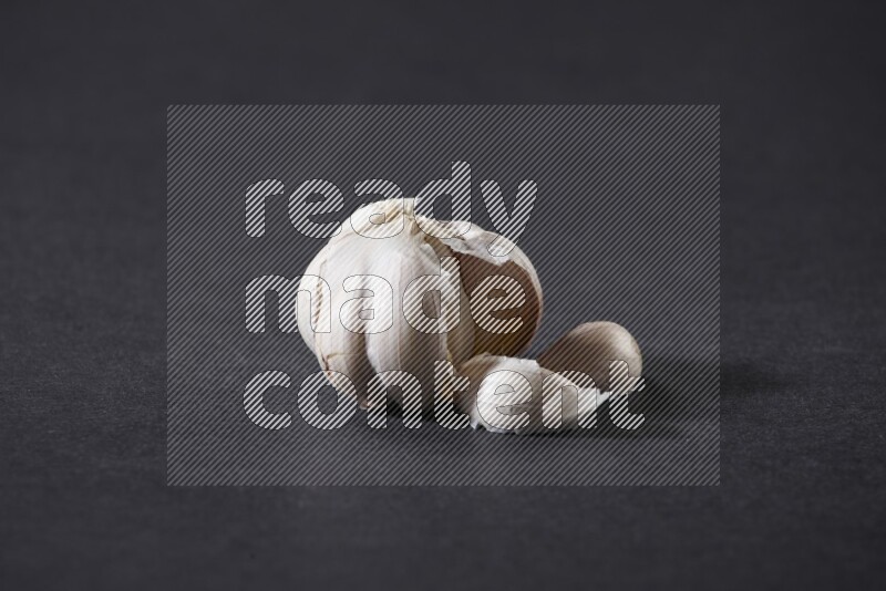 A whole garlic bulb placed on a black flooring